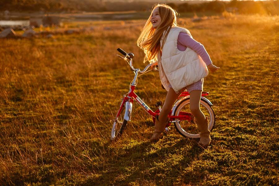 Sesión infantil en exteriores en El Escorial con bici al atardecer