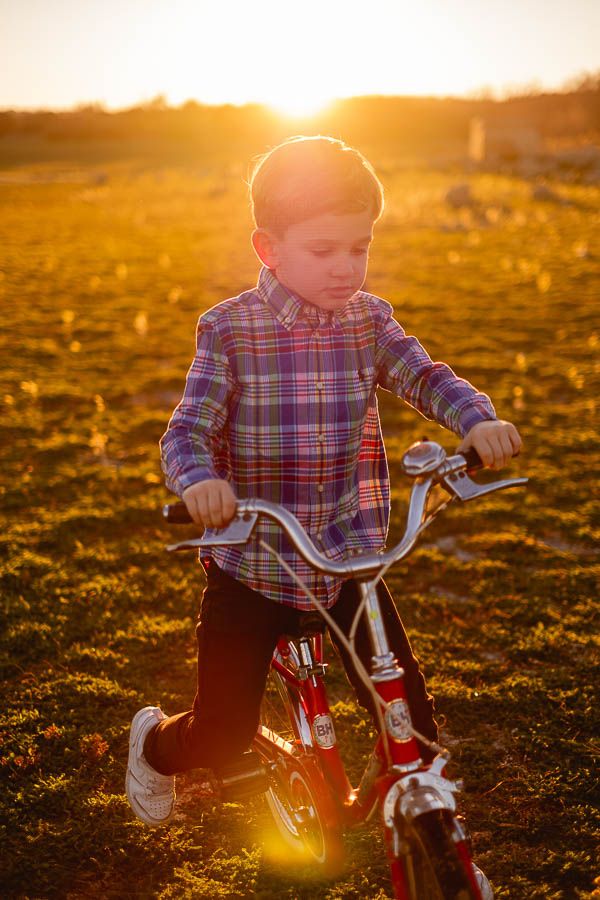 Hermanos jugando en bicicleta al atardecer en El Escorial Madrid