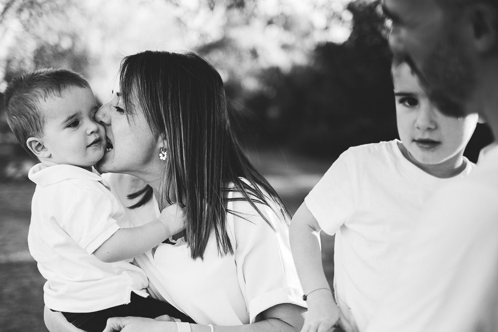 momentos de juego en familia durante sesión infantil al atardecer en el campo