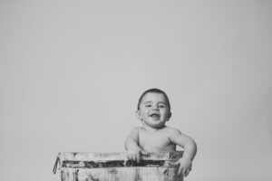 bebé sentado sonriendo en sesión de fotos infantil - en el campito