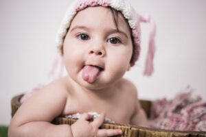 bebé sonriente sacando la lengua en sesión de fotos infantil - en el campito