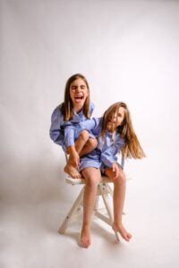 fotografia infantil en estudio dos hermanas sentadas fondo claro madrid