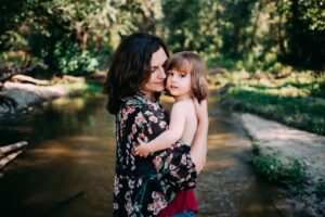 madre abrazando a su hija en sesión de fotos familiar natural en exterior en Madrid Rubén Mejías En el Campito