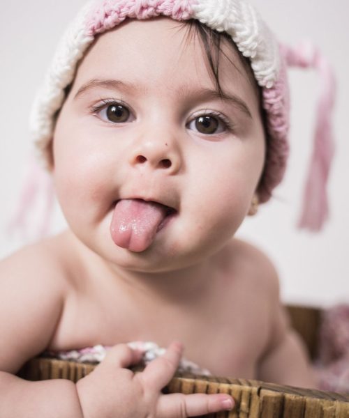 bebé sonriente sacando la lengua en sesión de fotos infantil - en el campito